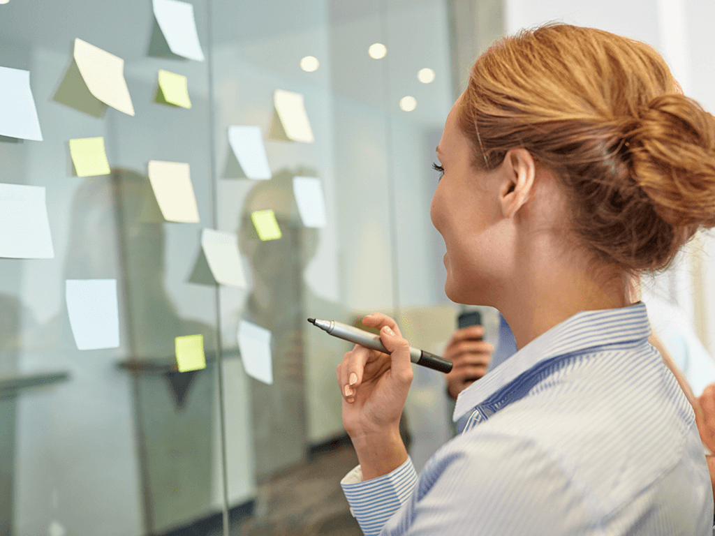 Daten anlysieren, auswerten, Frau, Post-its an einer Wand