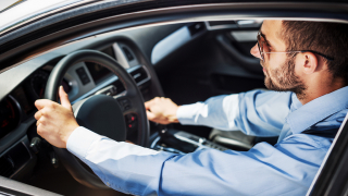 man behind steering wheel